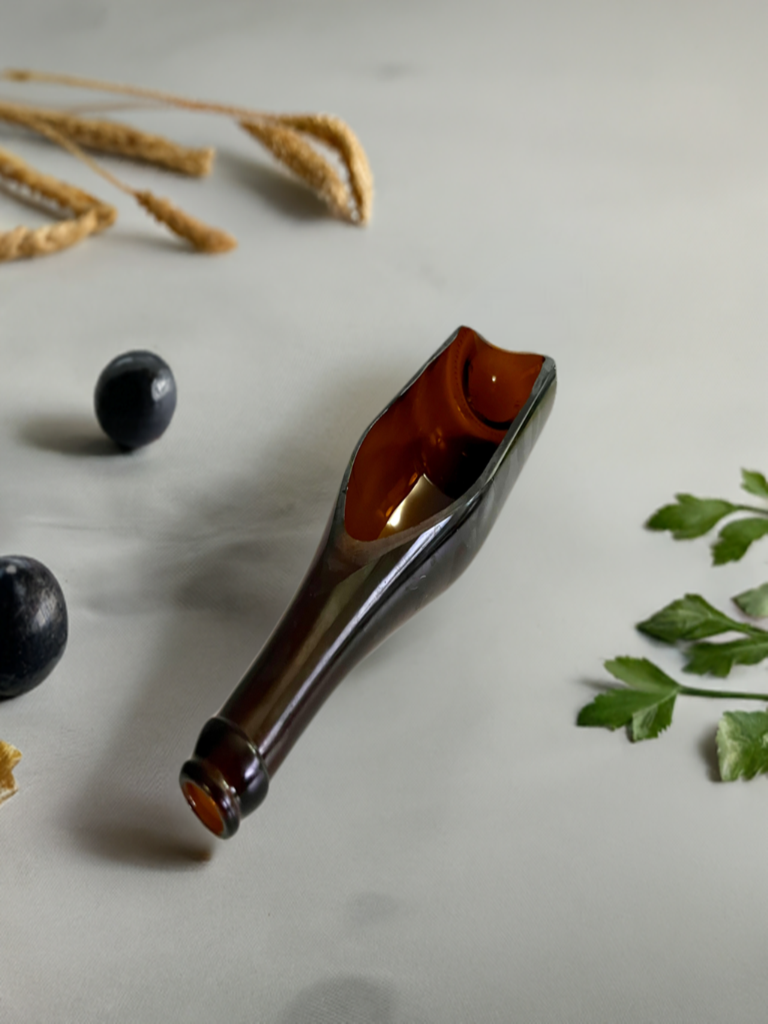 A horizontally side cut wine bottle crafted as a planter, in brown color, with no visible plants.