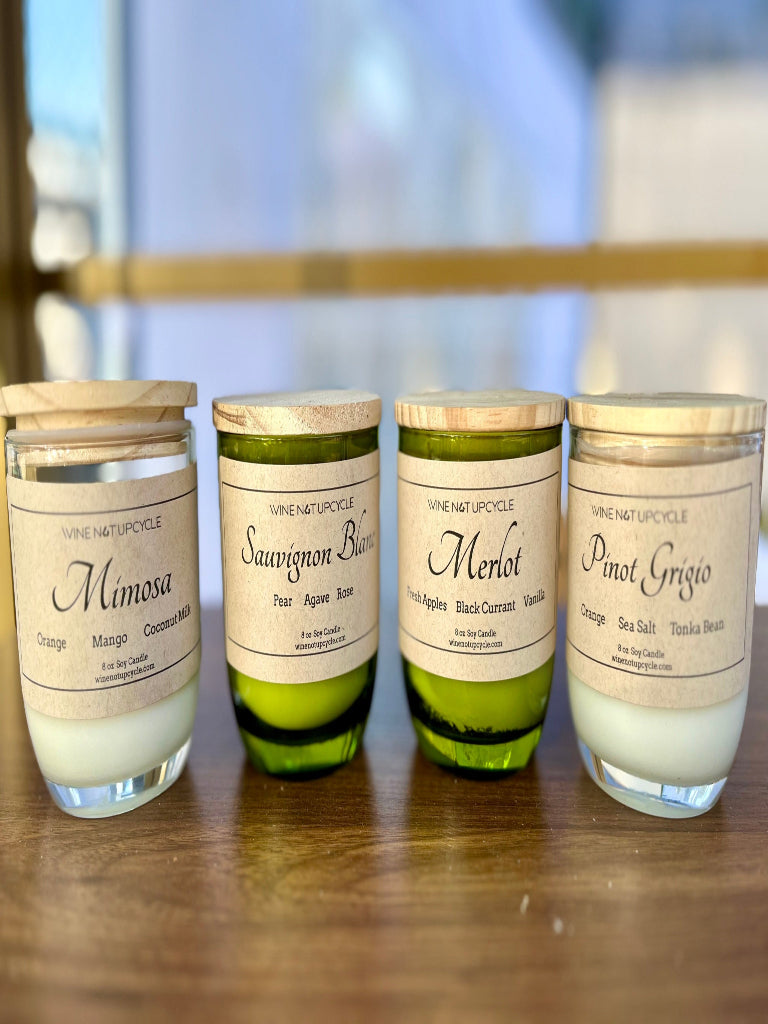 Four candles with labels on a wooden surface